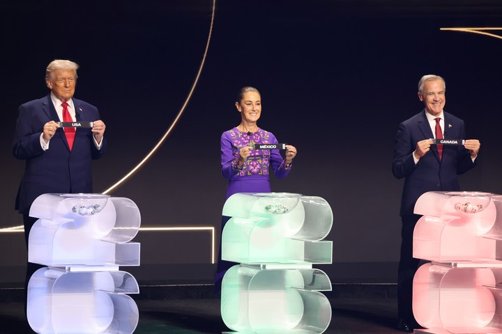 El presidente de Estados Unidos, Donald Trump, la presidenta de México, Claudia Sheinbaum, y el primer ministro de Canadá, Mark Carney, sostienen papeles con los nombres se sus países durante el sorteo del Mundial. (Foto: EFE)